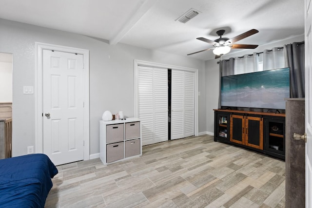 interior space with beam ceiling, ceiling fan, and light wood-type flooring