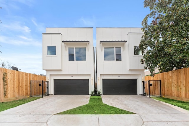 view of front of home featuring a garage, concrete driveway, and fence