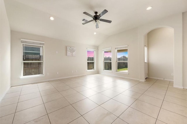 unfurnished room featuring ceiling fan, light tile patterned floors, and vaulted ceiling