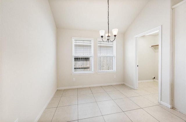 tiled spare room with lofted ceiling and a chandelier