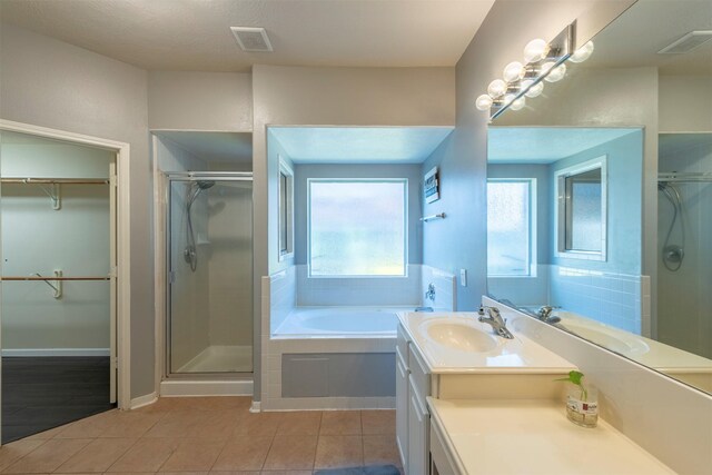 bathroom with independent shower and bath, vanity, and tile patterned floors