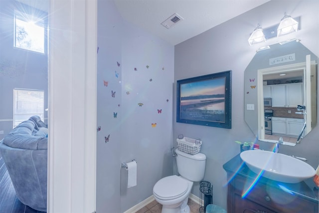 bathroom featuring tasteful backsplash, vanity, and toilet