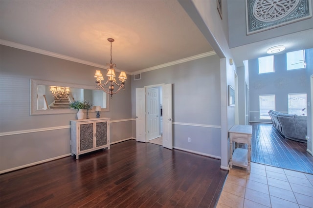 dining room featuring hardwood / wood-style flooring, crown molding, and a notable chandelier