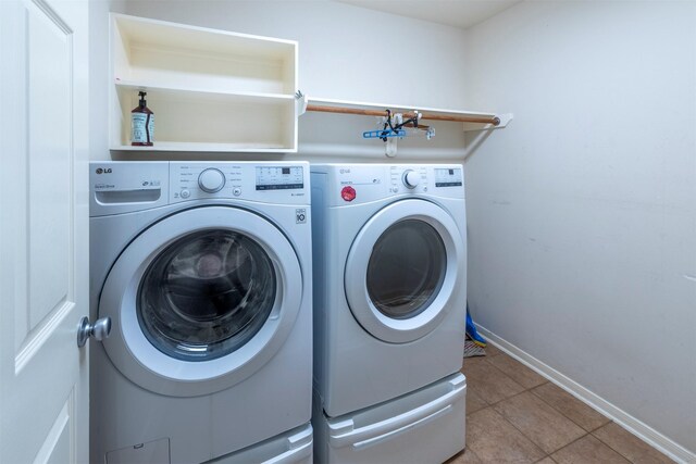 laundry area featuring light tile patterned flooring and washing machine and dryer