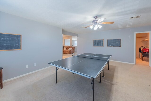 recreation room with ceiling fan and light colored carpet