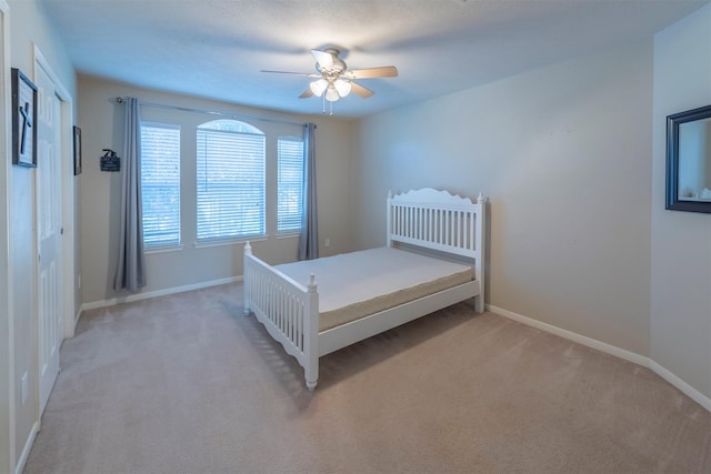 unfurnished bedroom featuring light colored carpet and ceiling fan