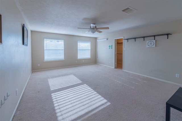 carpeted empty room featuring ceiling fan and a textured ceiling