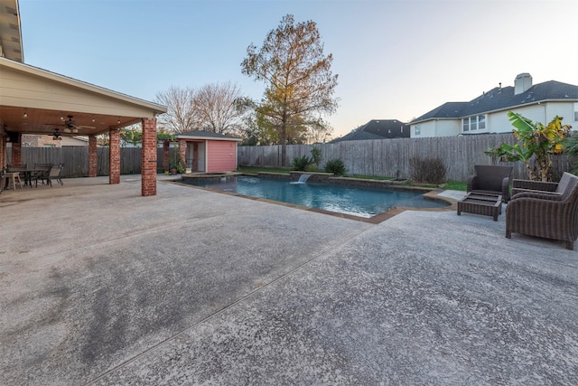 view of swimming pool with a storage shed, a patio, and ceiling fan