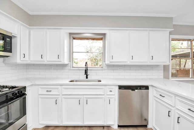 kitchen featuring light stone countertops, sink, white cabinets, and stainless steel appliances