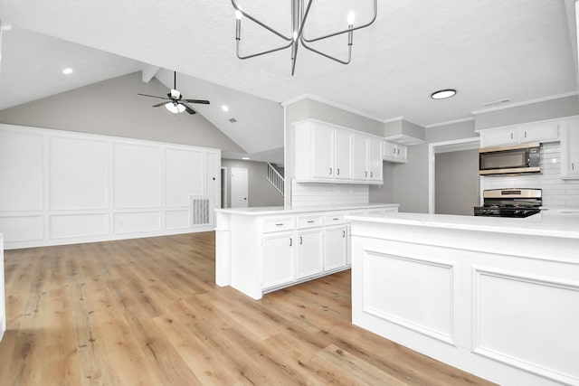 kitchen featuring vaulted ceiling with beams, tasteful backsplash, white cabinetry, kitchen peninsula, and stainless steel appliances