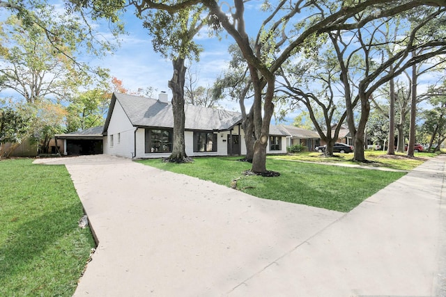 view of front of house with a carport and a front lawn