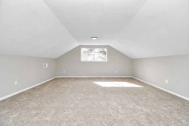 bonus room with light carpet and lofted ceiling