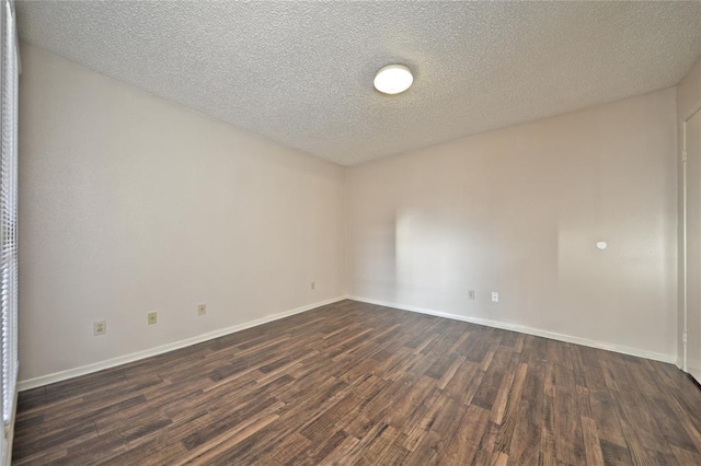 unfurnished room featuring dark hardwood / wood-style flooring and a textured ceiling