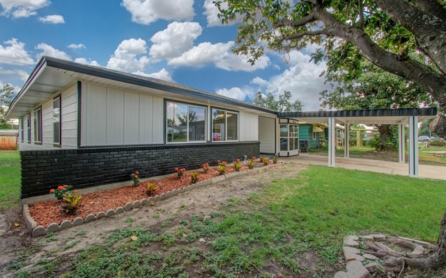 view of side of home with a yard and a carport