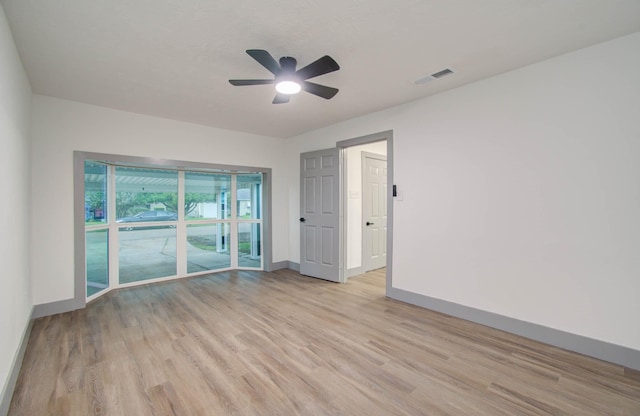 empty room with ceiling fan and light hardwood / wood-style flooring