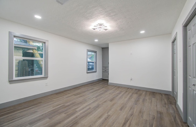 unfurnished bedroom with wood-type flooring and a textured ceiling