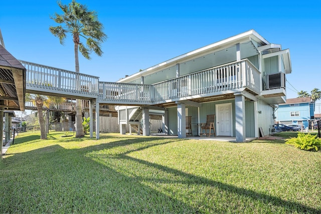 rear view of house with a lawn and a wooden deck