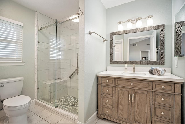 bathroom with tile patterned floors, vanity, toilet, and walk in shower