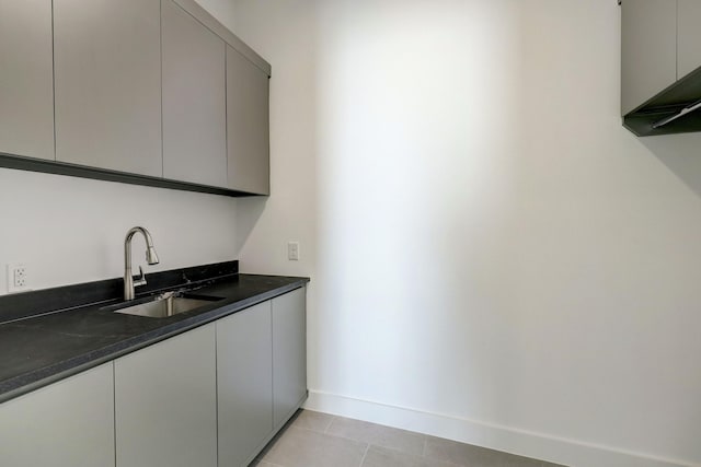 laundry area featuring sink and light tile patterned flooring