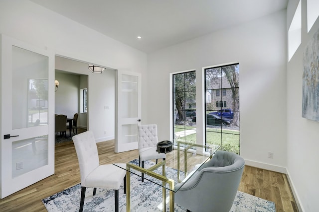 dining space featuring wood-type flooring, a wealth of natural light, and french doors