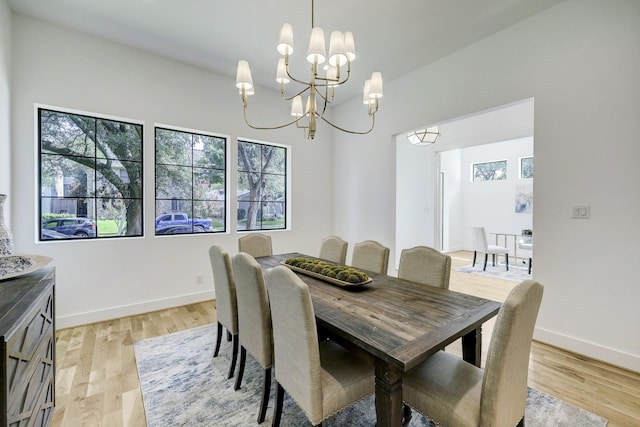 dining area with light hardwood / wood-style floors and a chandelier