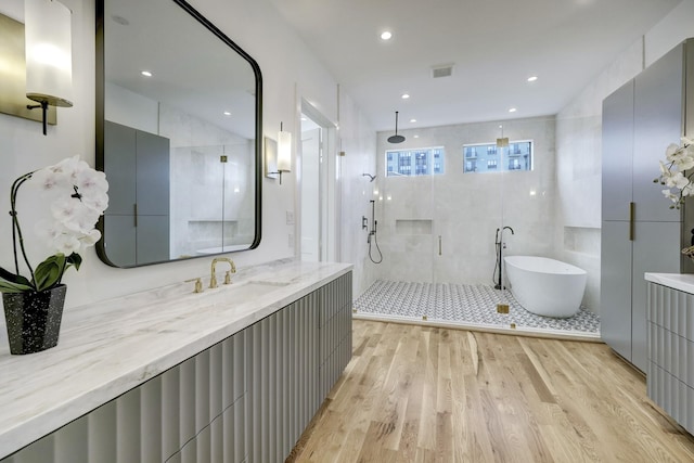 bathroom featuring vanity, separate shower and tub, wood-type flooring, and tile walls