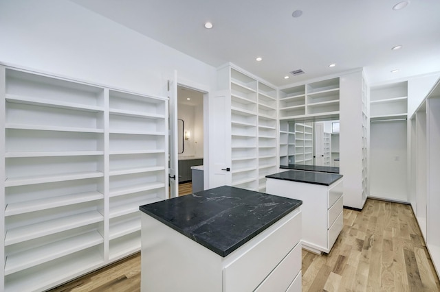 kitchen featuring light hardwood / wood-style floors, a kitchen island, and white cabinetry