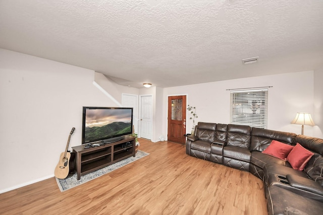 living room featuring light hardwood / wood-style floors and a textured ceiling