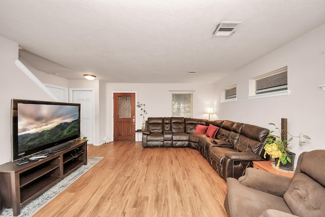 living room featuring a textured ceiling and light hardwood / wood-style floors