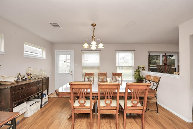 dining area with a chandelier and light wood-type flooring