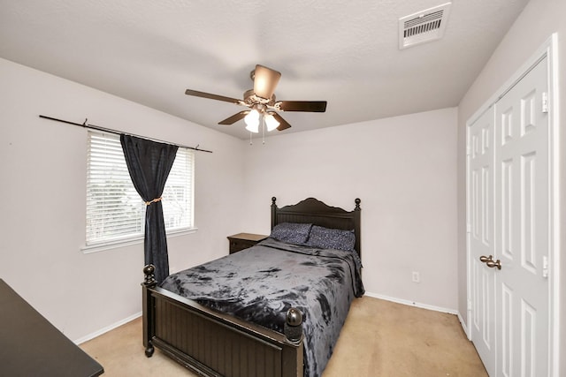 carpeted bedroom featuring a closet and ceiling fan