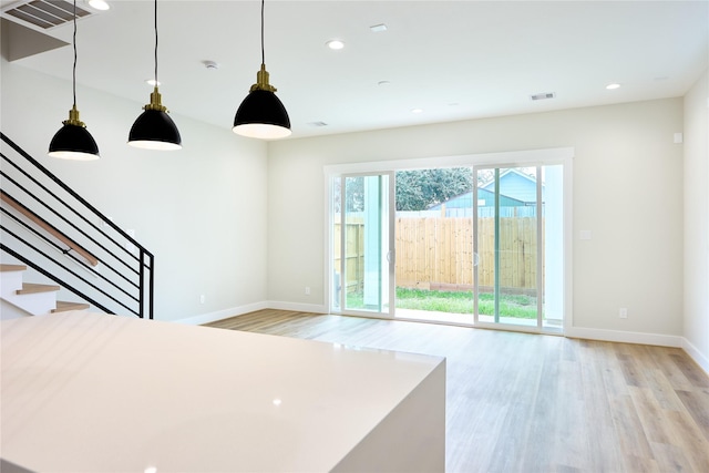 interior space featuring decorative light fixtures and light hardwood / wood-style floors