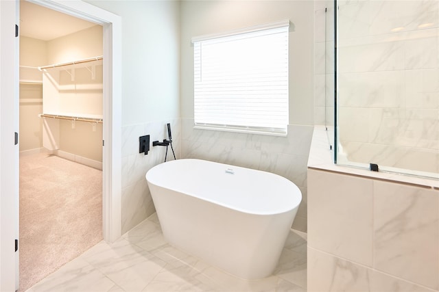 bathroom with a bathtub and tile walls