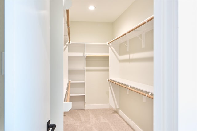 walk in closet featuring light carpet