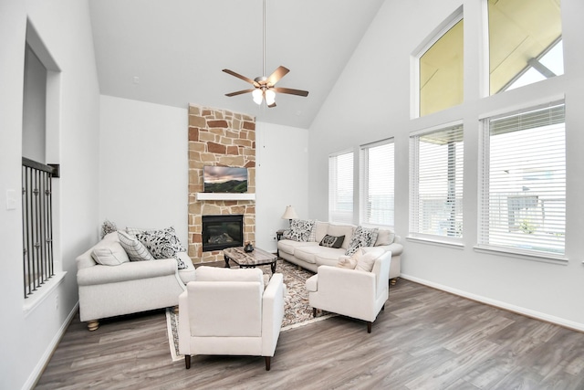 living room with high vaulted ceiling, hardwood / wood-style flooring, ceiling fan, and a fireplace