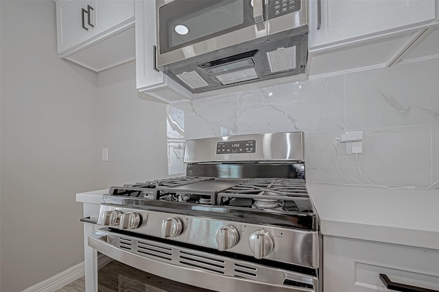 kitchen with white cabinets, wood-type flooring, and appliances with stainless steel finishes