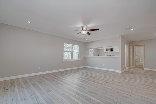 unfurnished living room featuring ceiling fan and light hardwood / wood-style floors