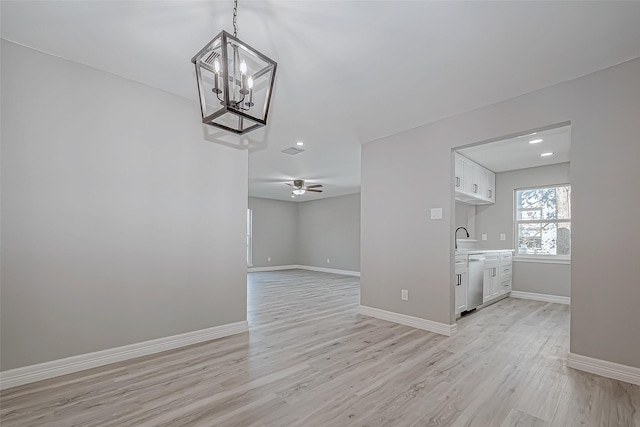 interior space with ceiling fan with notable chandelier, light hardwood / wood-style floors, and sink