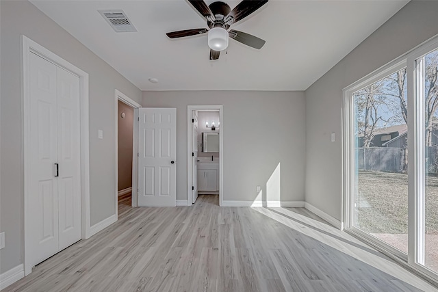 unfurnished bedroom featuring ensuite bath, ceiling fan, and light wood-type flooring