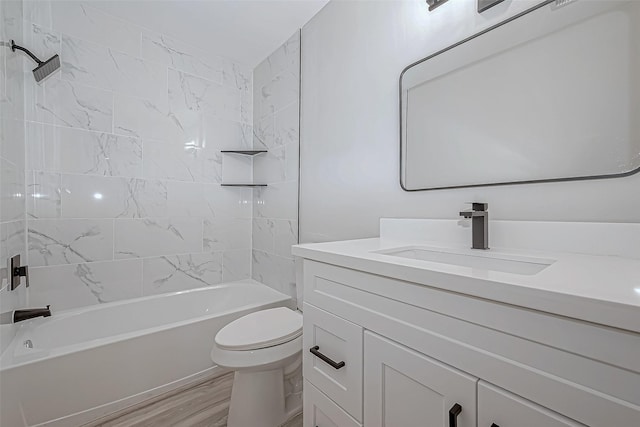 full bathroom with vanity, tiled shower / bath combo, hardwood / wood-style flooring, and toilet