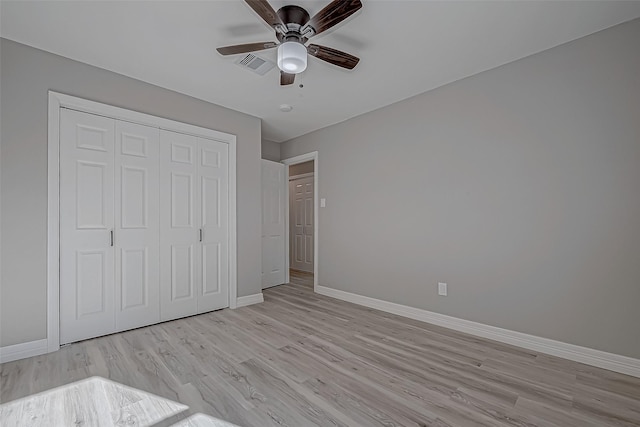 unfurnished bedroom featuring ceiling fan, a closet, and light wood-type flooring