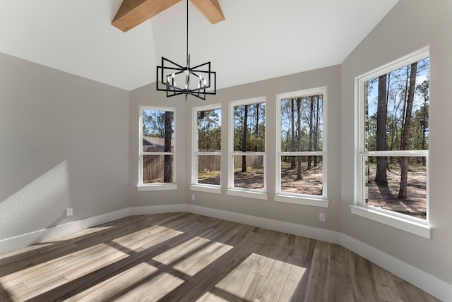 unfurnished sunroom featuring vaulted ceiling with beams, plenty of natural light, and a chandelier