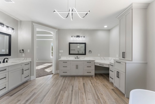 bathroom featuring hardwood / wood-style floors, vanity, and a notable chandelier