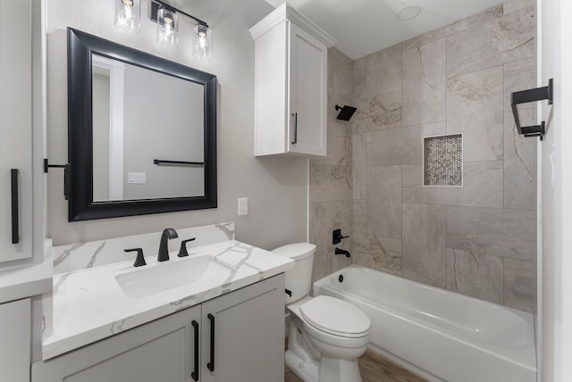 full bathroom featuring toilet, vanity, and tiled shower / bath