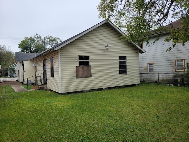 rear view of house with a yard and cooling unit