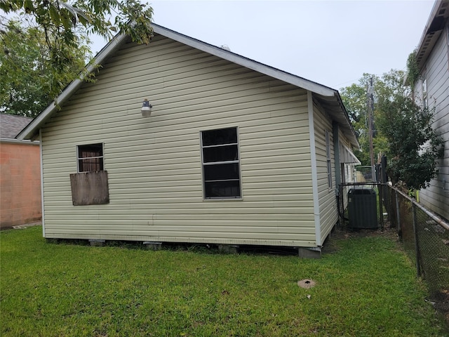 view of side of home featuring a yard and central AC