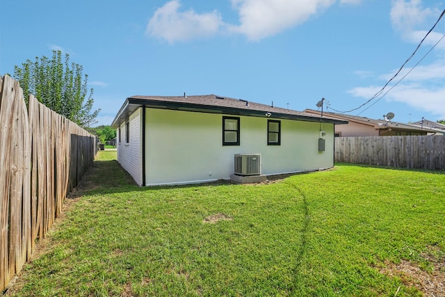 rear view of house with a yard and central AC