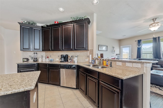 kitchen with kitchen peninsula, tasteful backsplash, sink, light tile patterned floors, and dishwasher