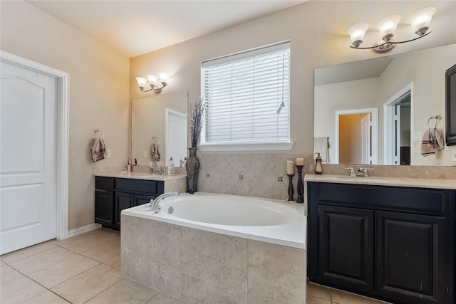 bathroom featuring tile patterned floors, vanity, and tiled bath