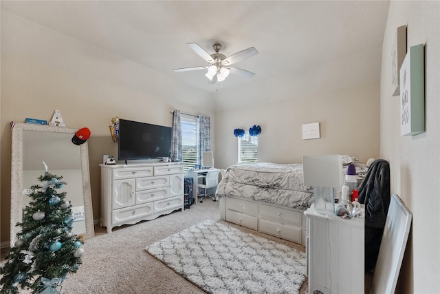 carpeted bedroom with ceiling fan and vaulted ceiling